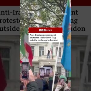 Anti-Iranian government protester tears down flag outside embassy in London. #Iran #London #BBCNews