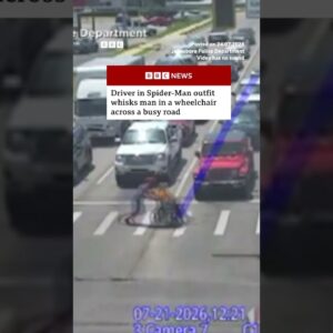 Driver in Spider-Man outfit helps man in wheelchair across busy road. #BBCNews #US