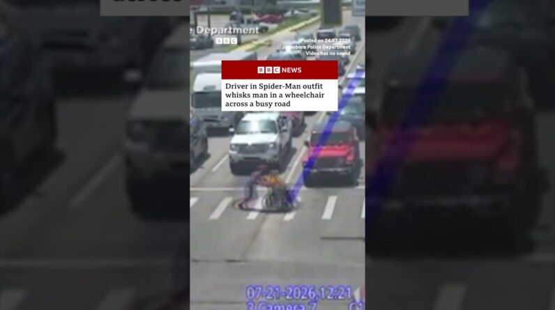 Driver in Spider-Man outfit helps man in wheelchair across busy road. #BBCNews #US